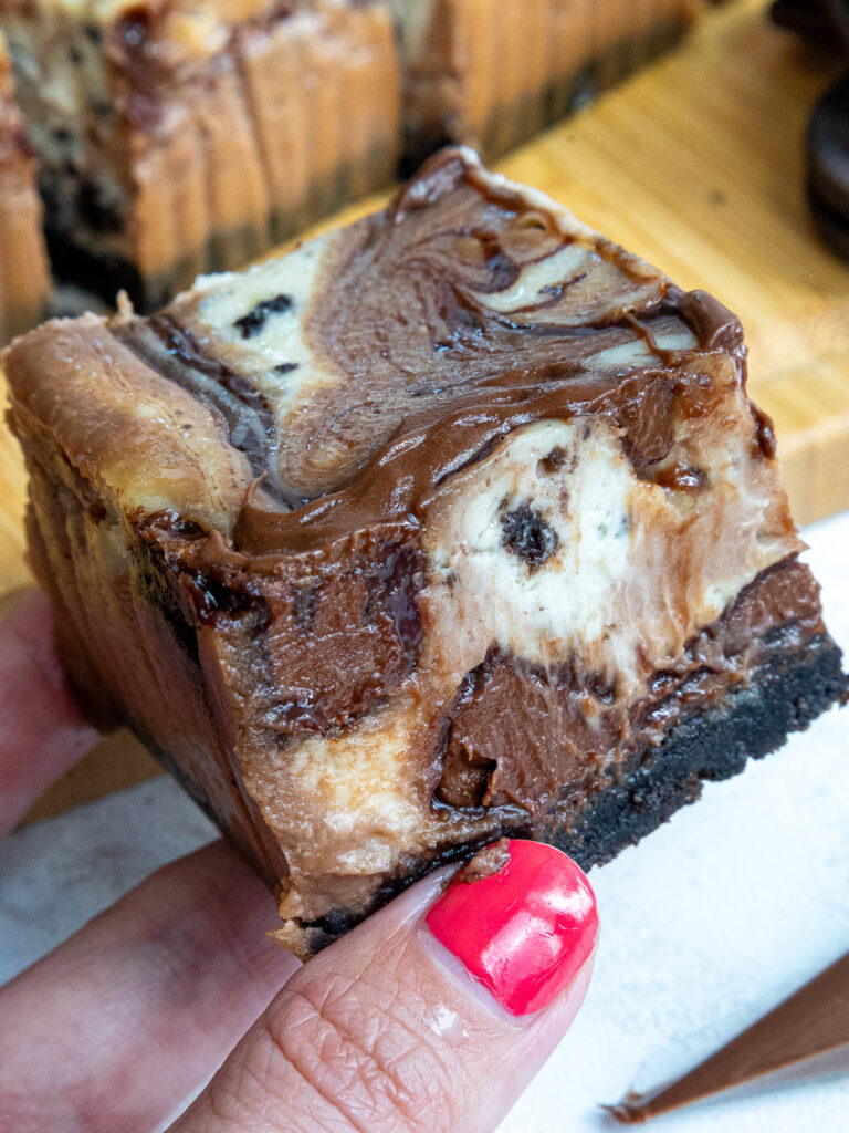 image of a nutella cheesecake bars being held up