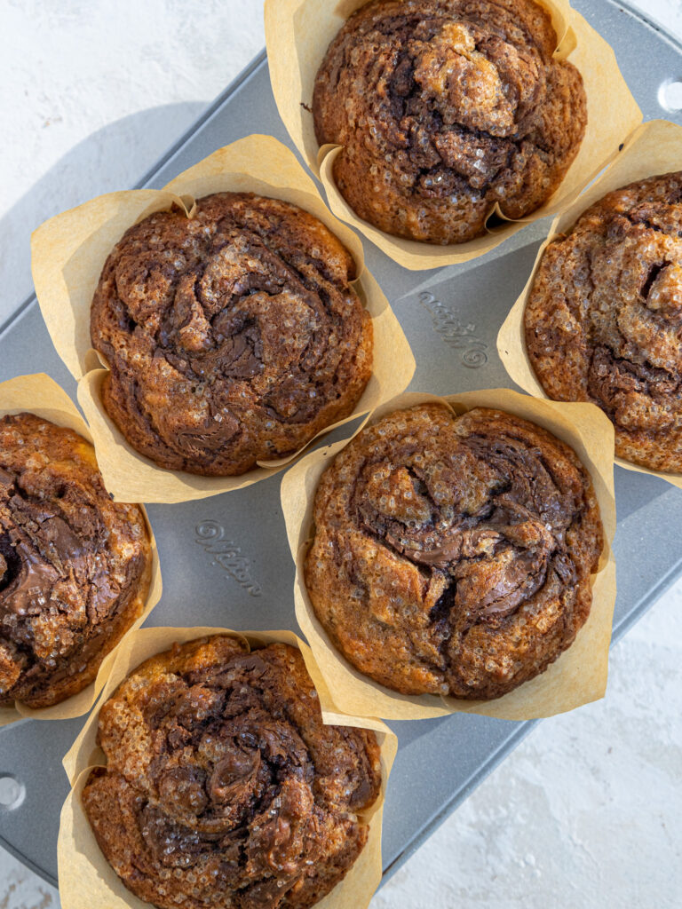 image of nutella banana nut muffins that have been baked and are cooling in the muffin pan