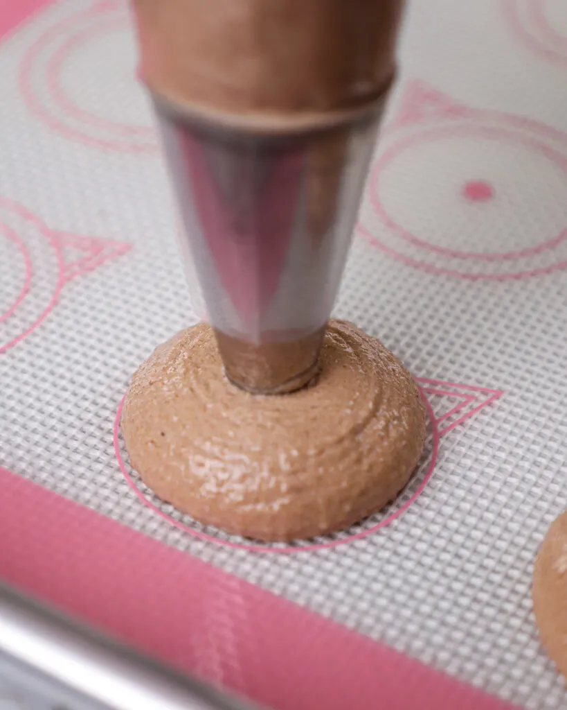 image of chocolate macarons being piped