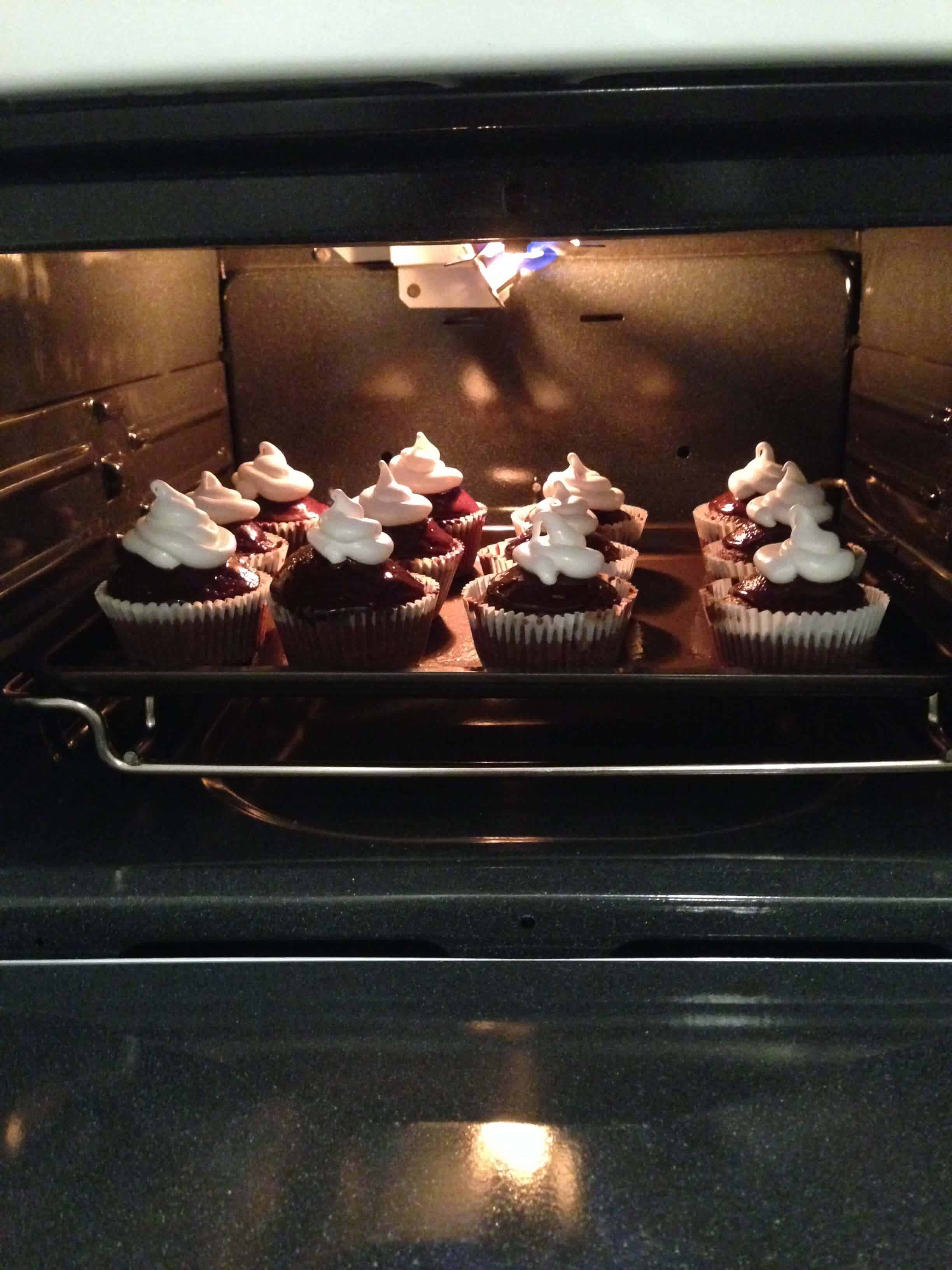image of Marshmallow S'mores Cupcakes being broiled to toast their marshmallow topping