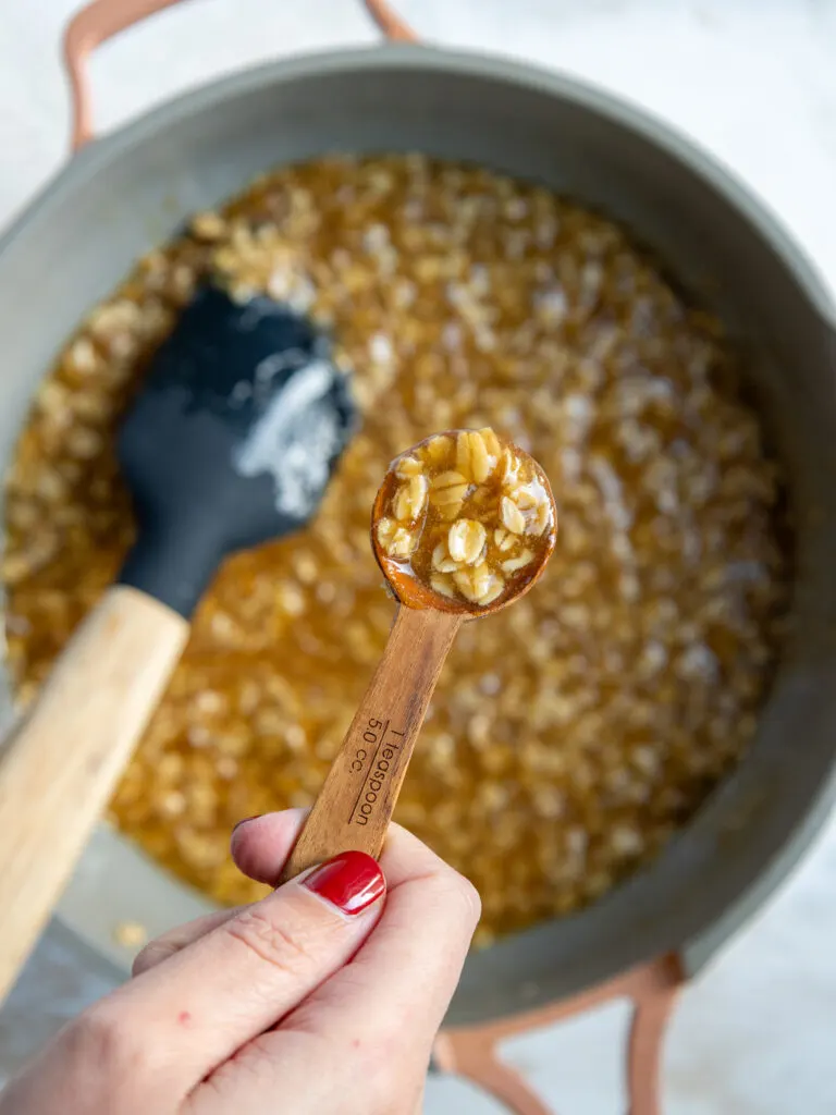 image of oatmeal lace cookie batter being scooped by the teaspoon to make each cookie