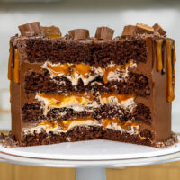 image of a milky way cake that's been cut into to show it's fluffy chocolate filling and caramel drizzle