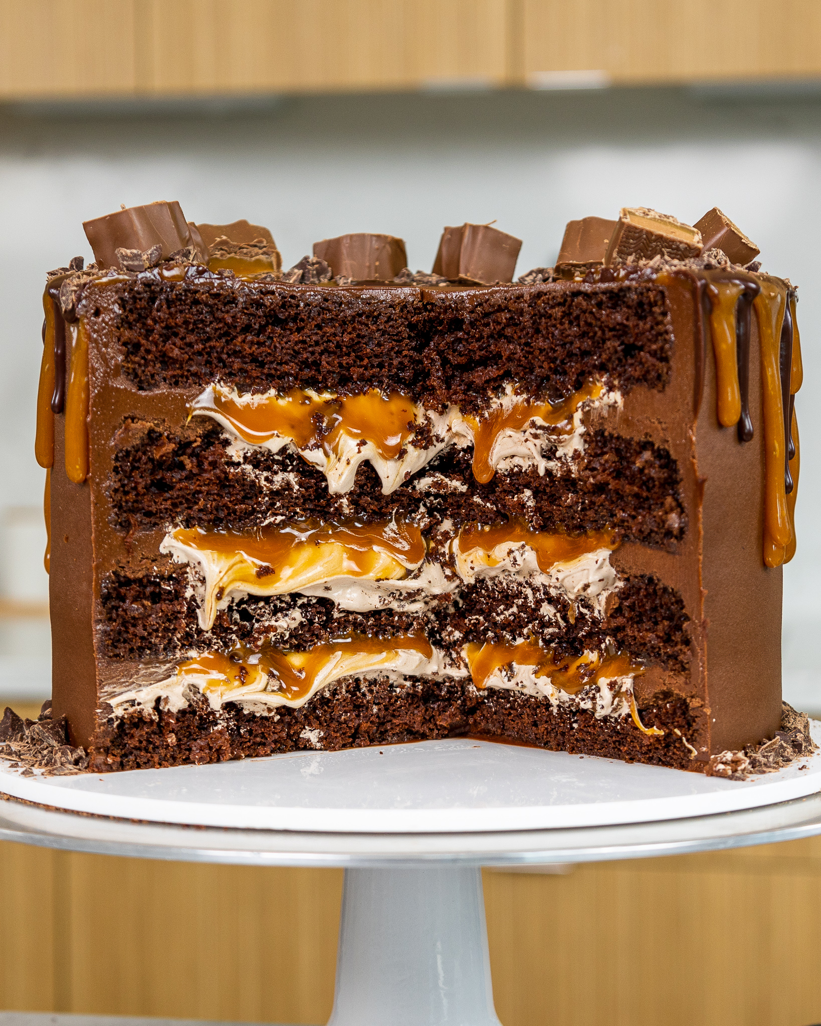 image of a milky way cake that's been cut into to show it's fluffy chocolate filling and caramel drizzle