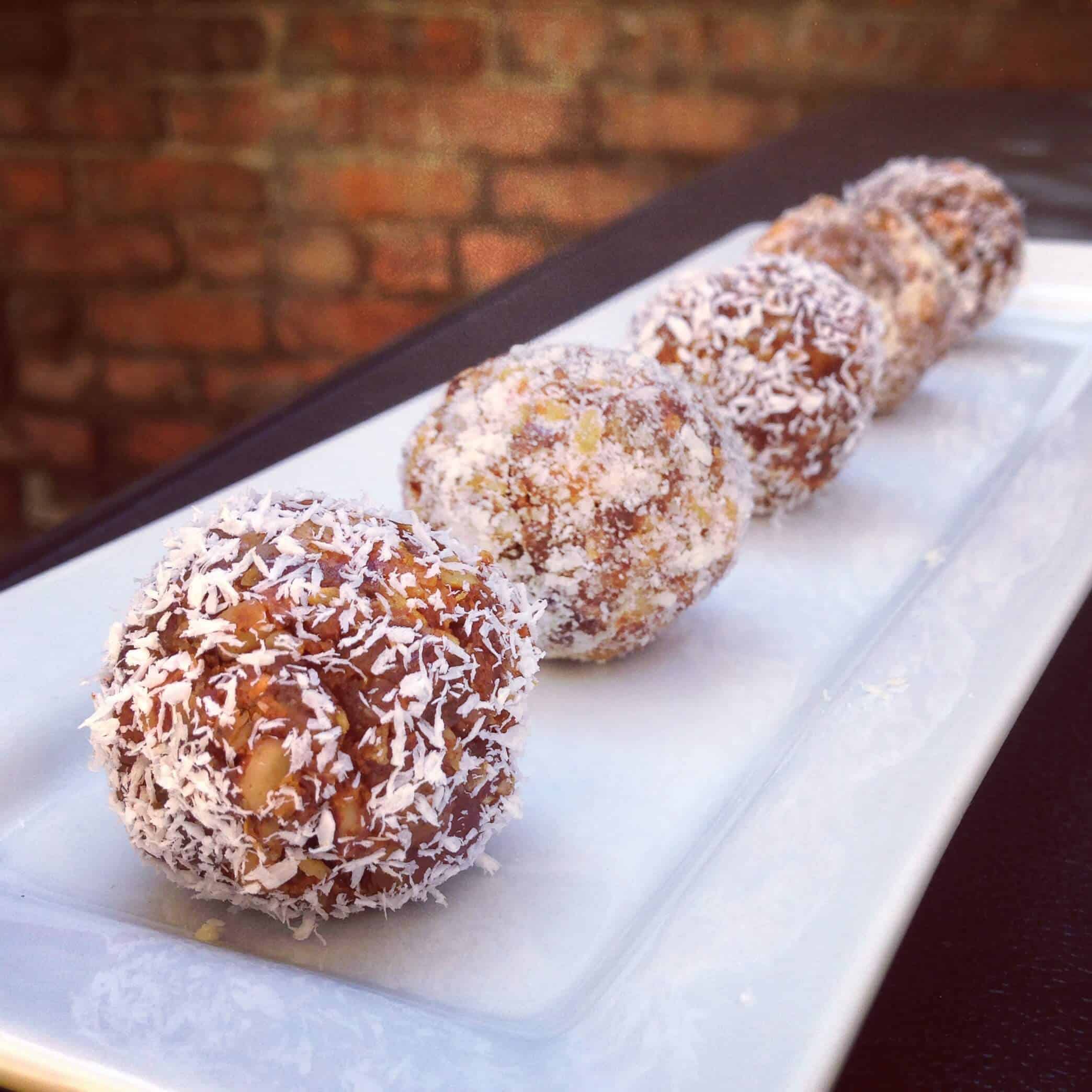 image of raw carrot cake balls dusted in shredded coconut