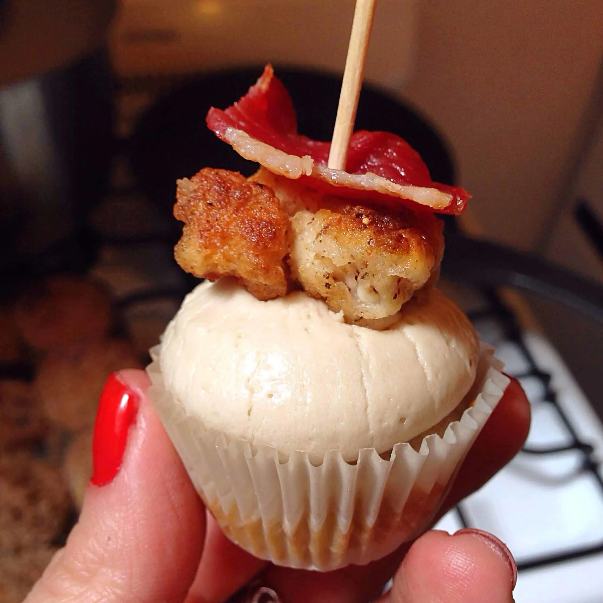 image of a chicken and waffles cupcakes frosted with maple buttercream and topped with bacon
