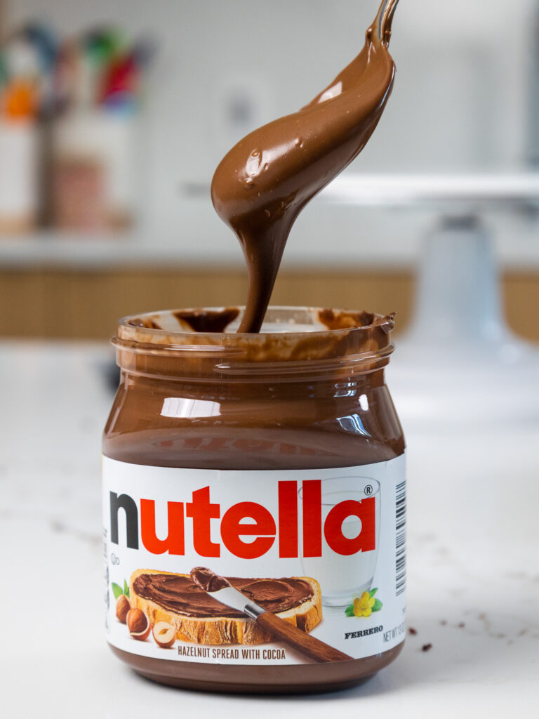 image of Nutella being scooped out of the container with a spoon