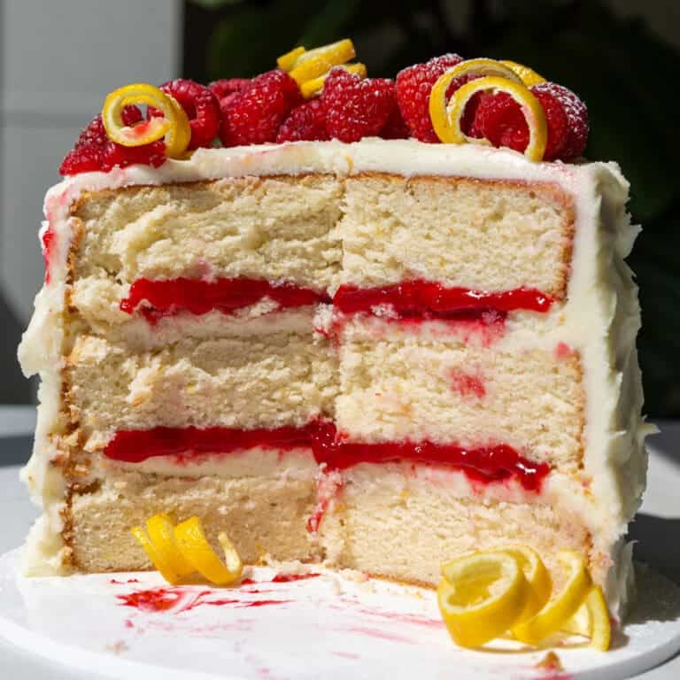 image of a lemon cake with raspberry filling that's been cut into to show how tender and moist it is