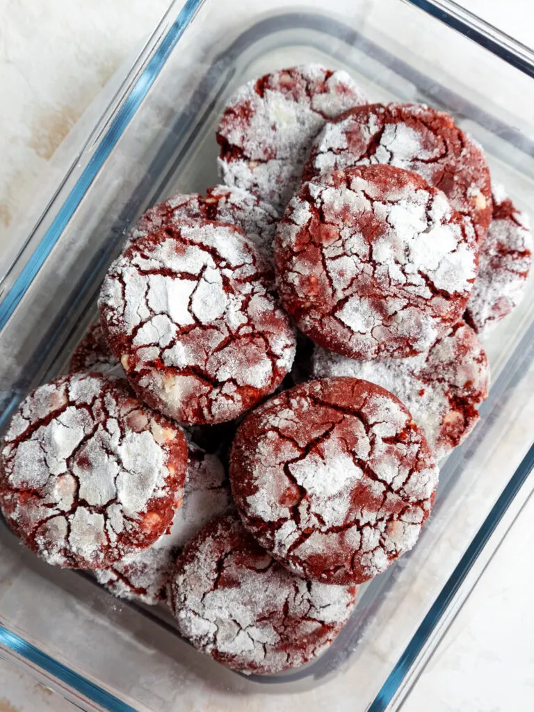 image of red velvet crinkle cookies in a glass container to be stored at room temperature