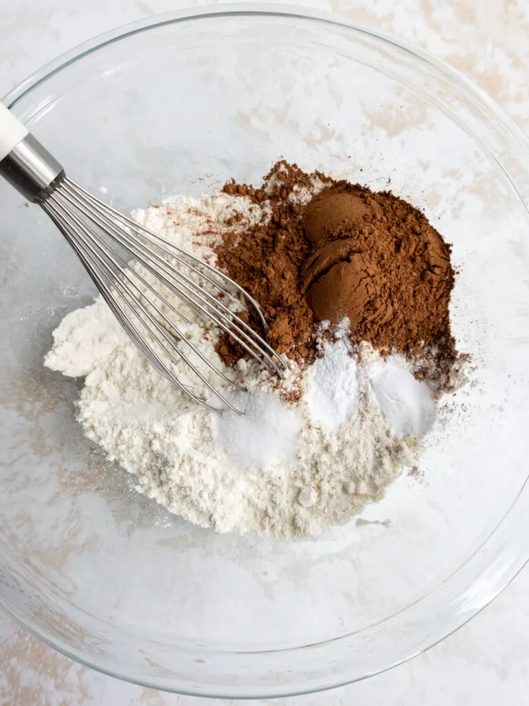 image of dry ingredients being whisked together to make red velvet crinkle cookies