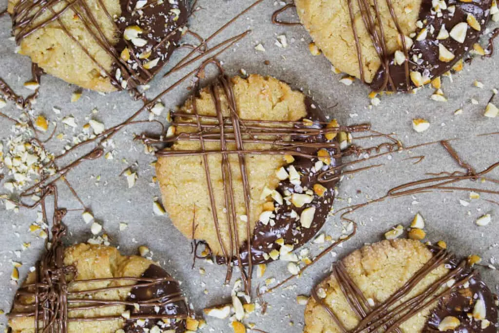 image of chocolate dipped peanut butter cookies decorated with drizzled chocolate