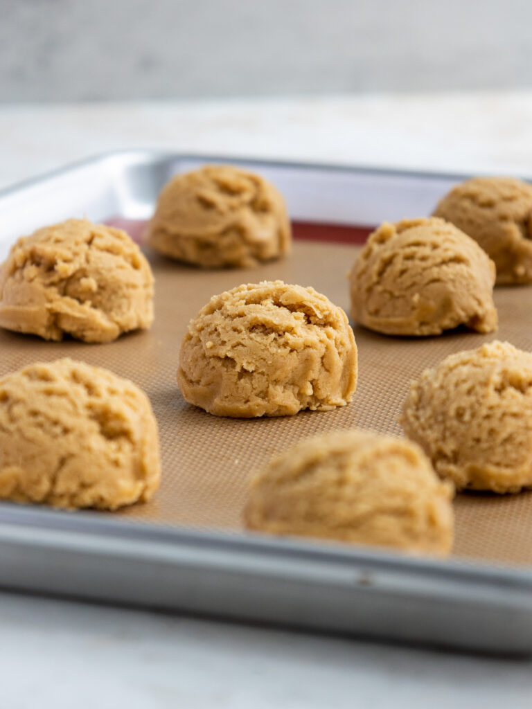 image of peanut butter cookie dough that's been scooped onto a baking sheet