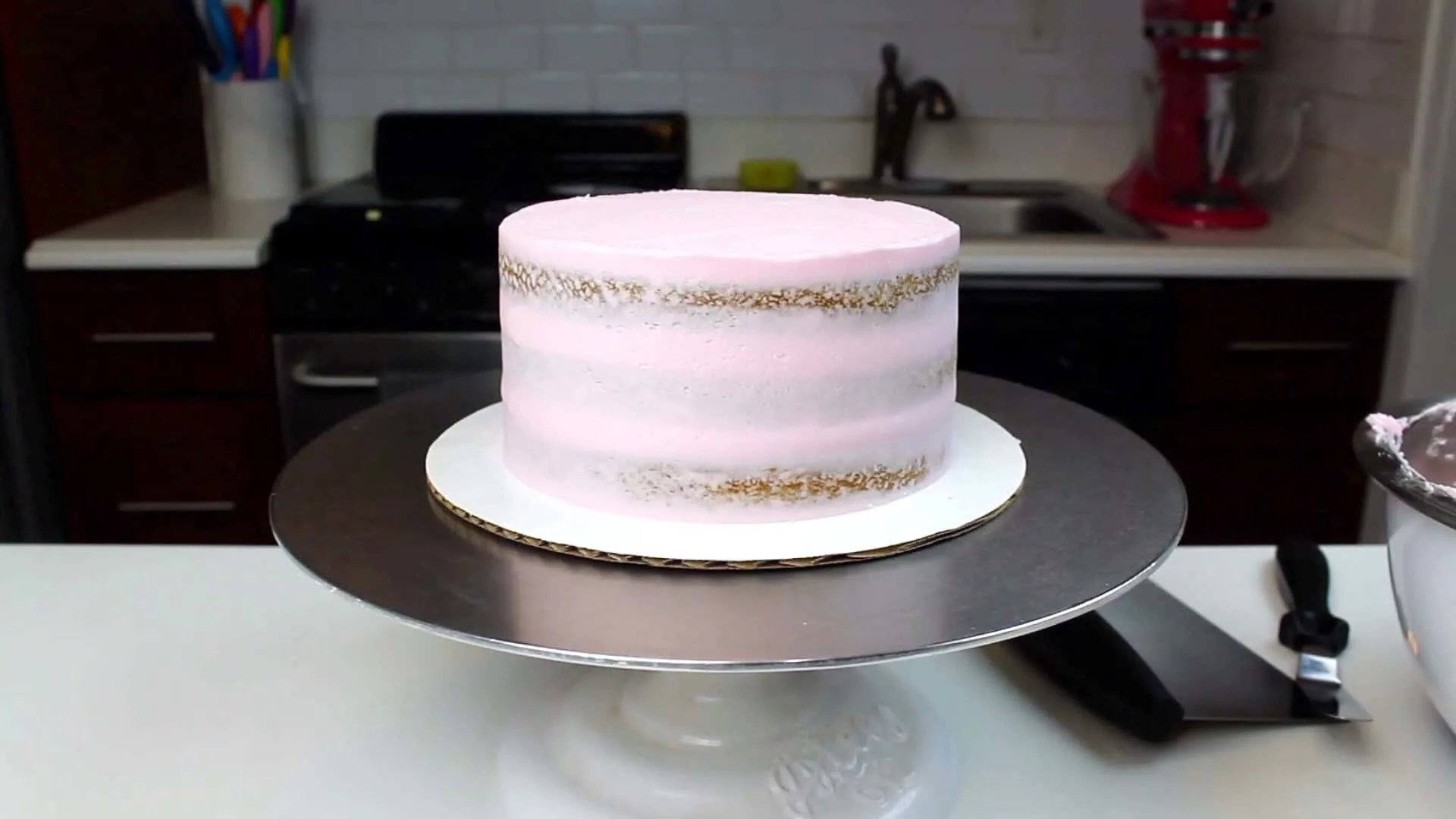 image of a vegan almond cake that has been crumb coated with vegan frosting
