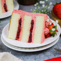 image of a vanilla layer cake recipe frosted with strawberry american buttercream