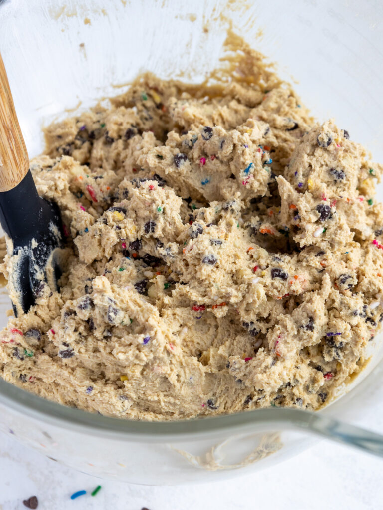 image of edible cookie dough cake filling that's been mixed in a glass bowl
