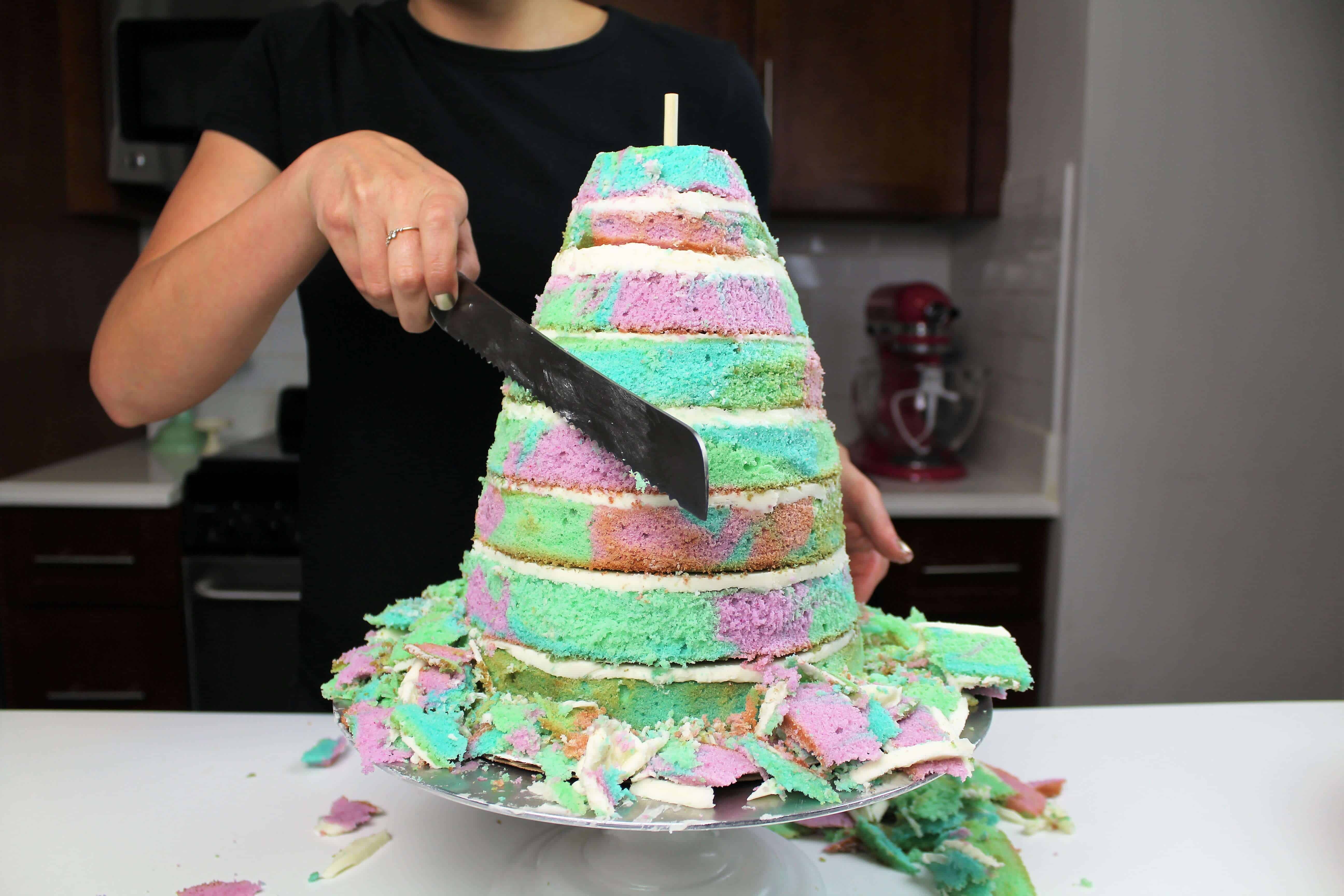 image of a mermaid tail cake being shaped using a serrated knife