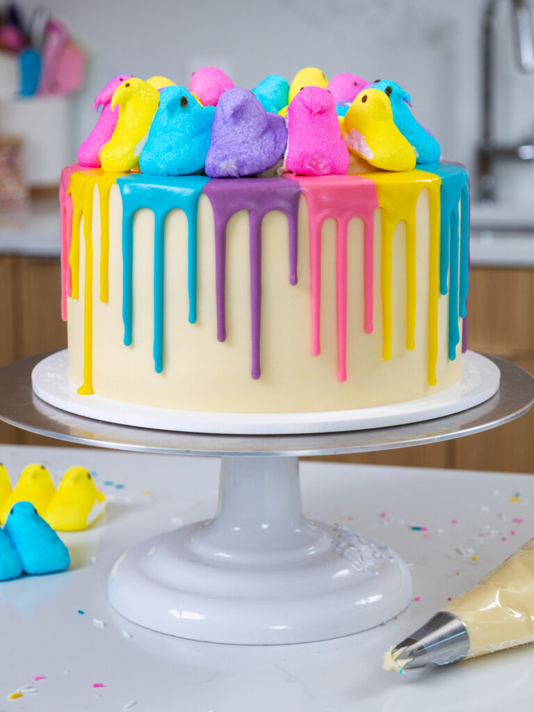 image of a cute peeps cake that's been decorated with colorful white chocolate ganache drips and different colored peeps