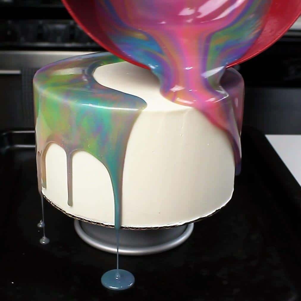 Pouring mirror glaze over chilled buttercream cake
