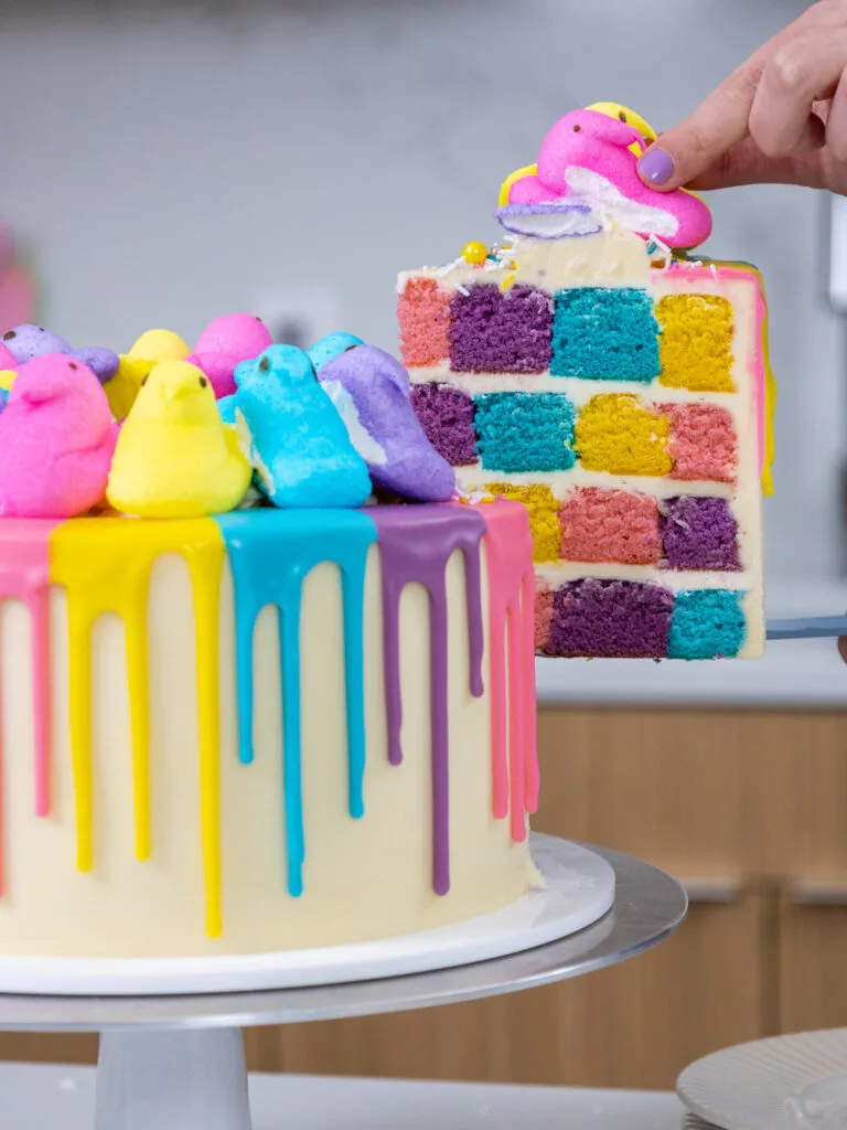 image of a slice of a checkerboard cake being pulled out of a Peeps cake