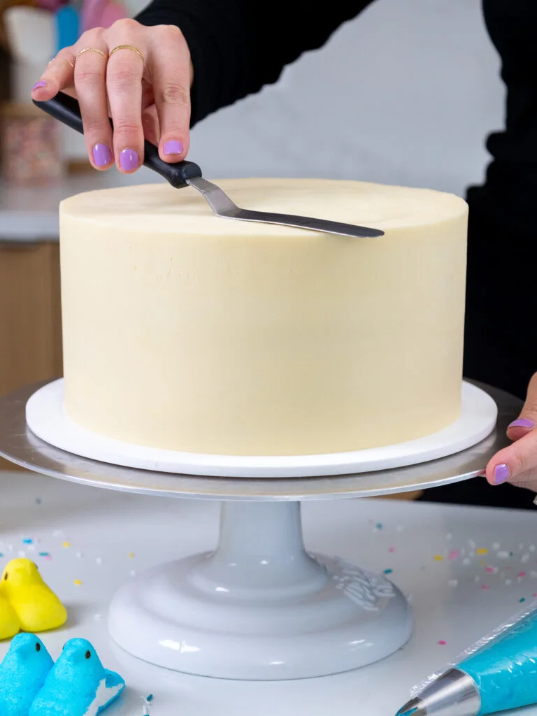 image of a second coat of frosting being smoothed onto a cake