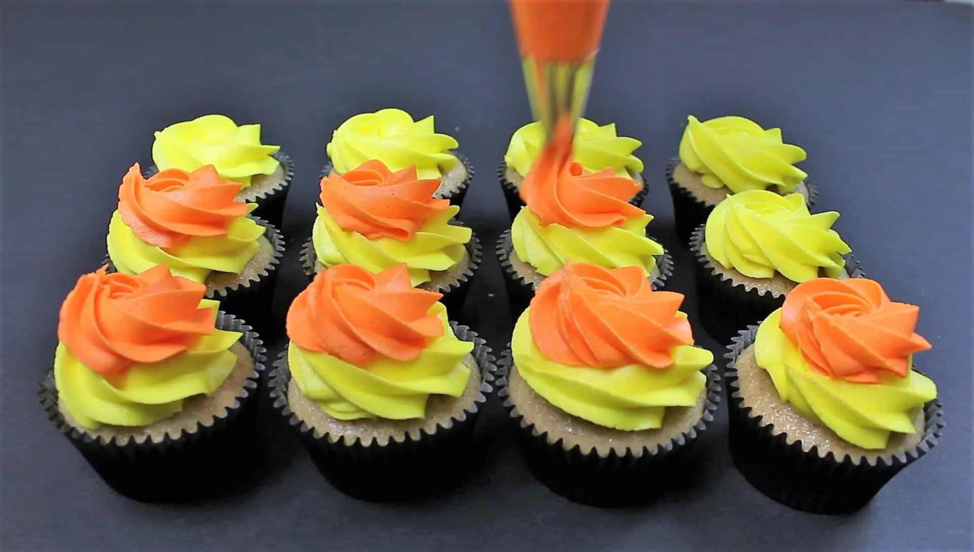 Image of Piping candy corn frosting onto these fireball cupackes