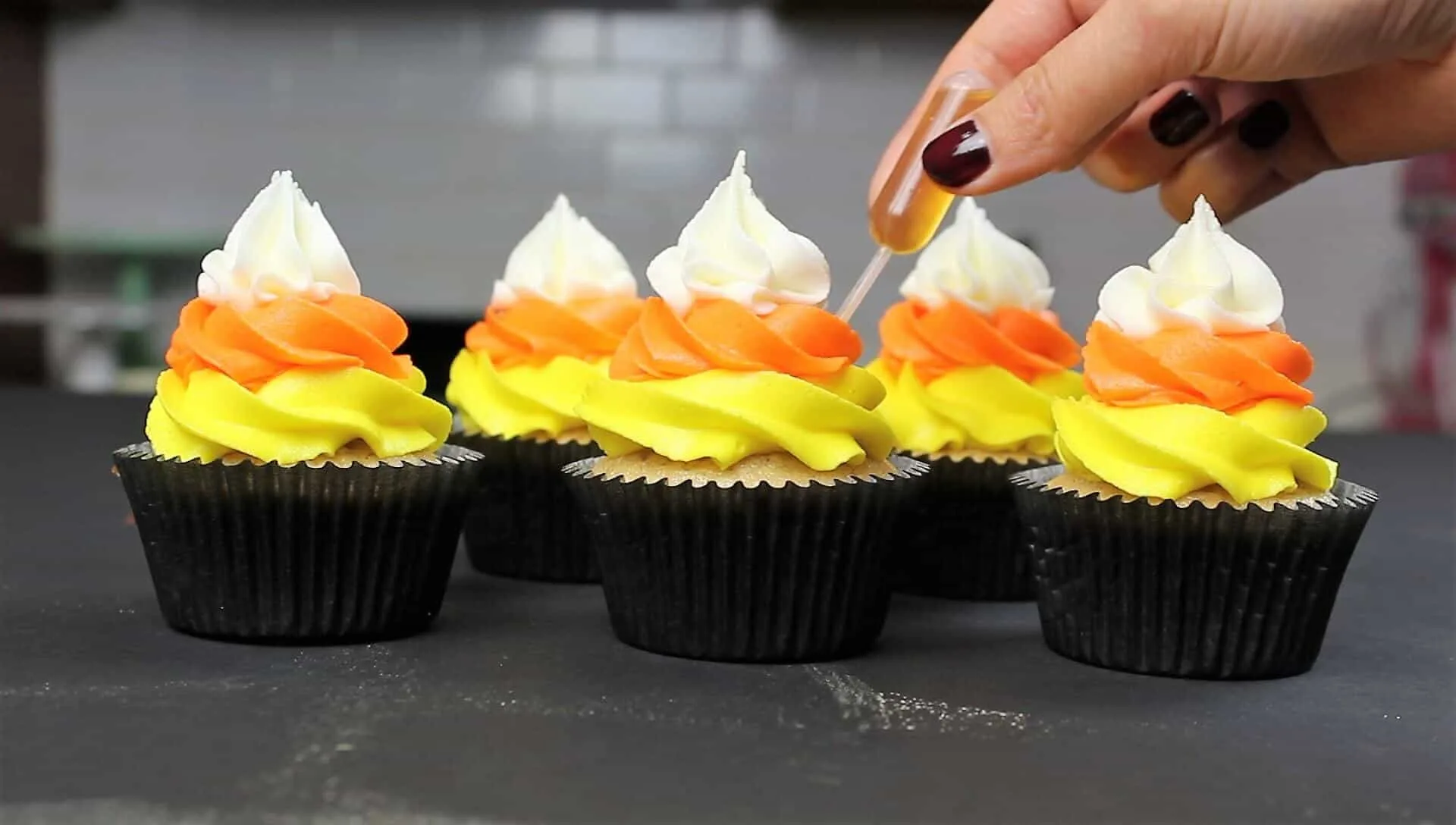 Photo of adding a pipette of fireball to top off the fireball cupcakes