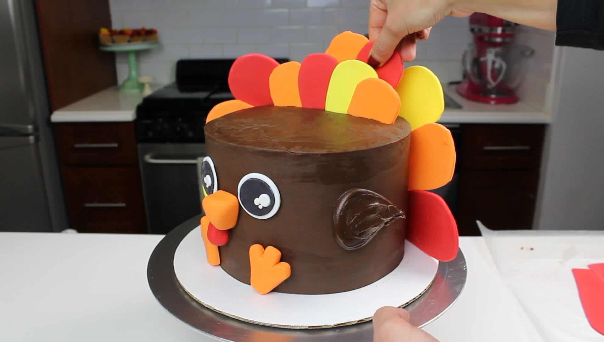 photo of adding feathers to turkey cake for thanksgiving