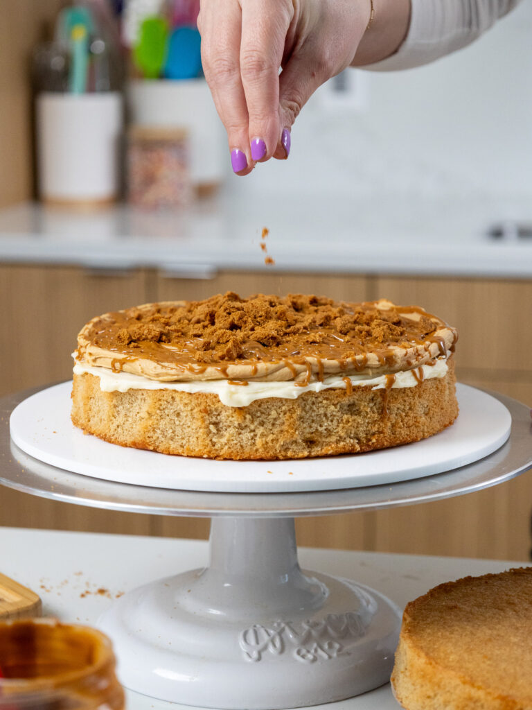image of biscoff cookies being added to a lotus cake