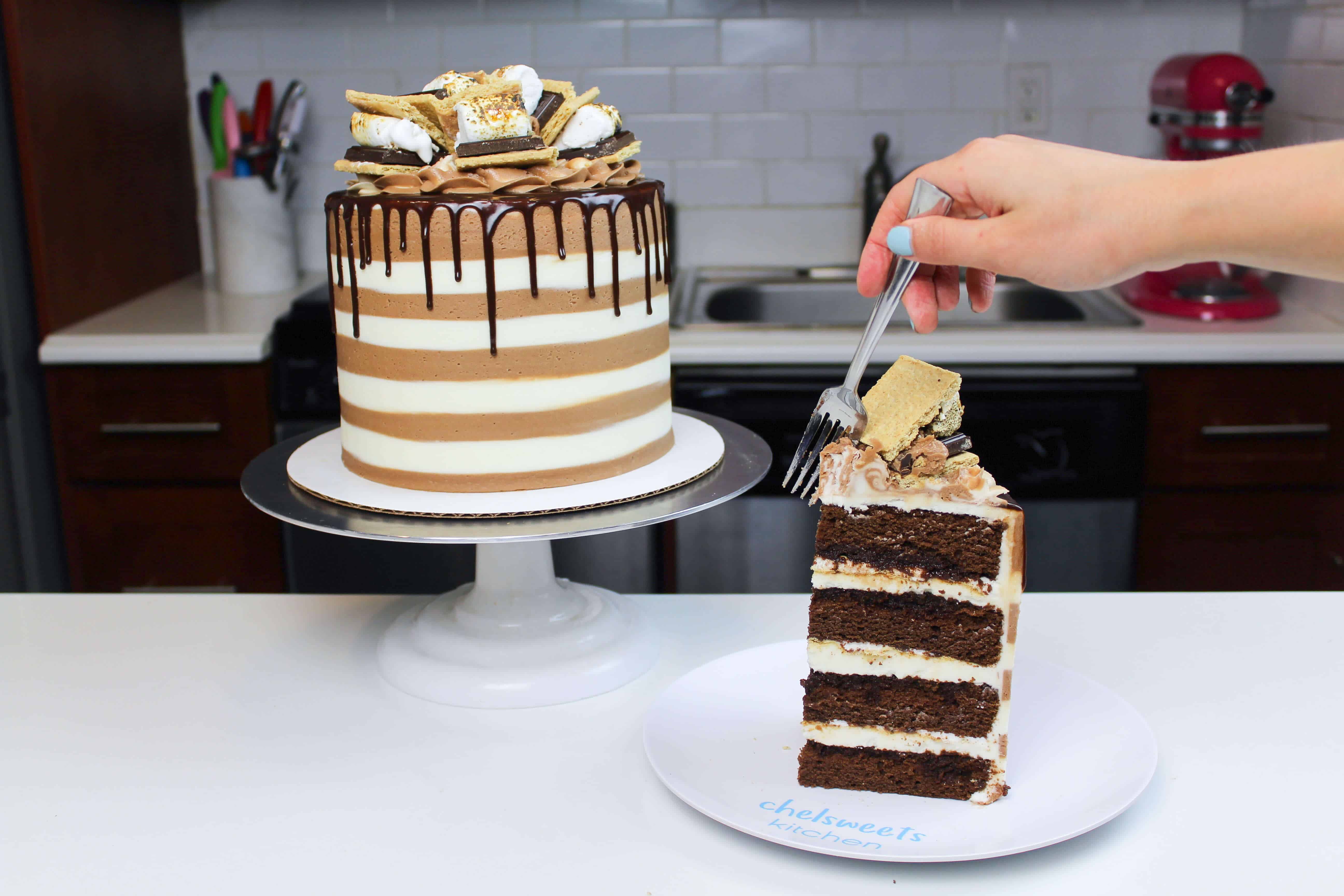 image of smores cake decorated with  a drip and cut into to show how moist the cake is
