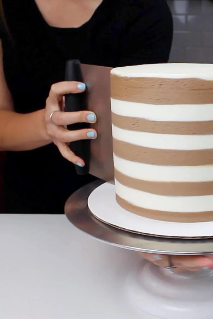 image of smoothing stripes on smores drip cake