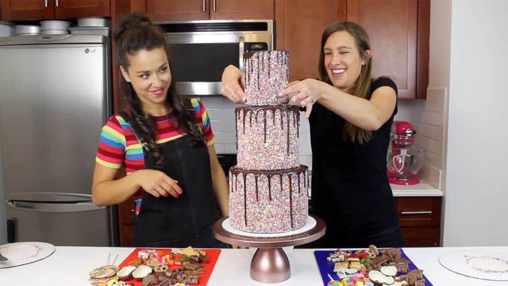 photo of adding top tier to sprinkle drip candy cake