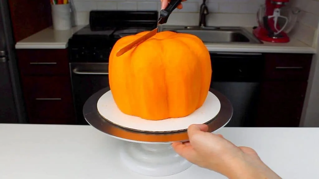 image of smoothing buttercream onto a pumpkin shaped cake