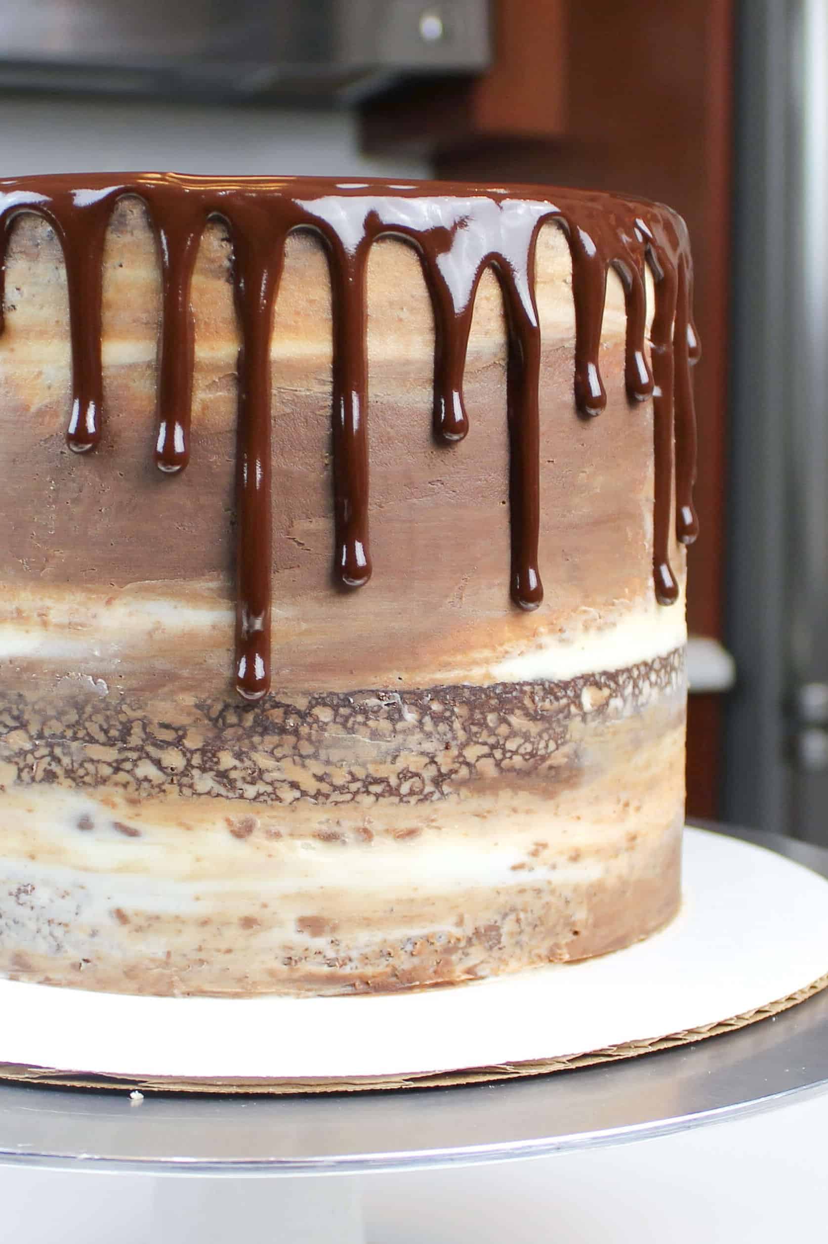 chocolate ganache drips on a semi naked frosted chocolate cake