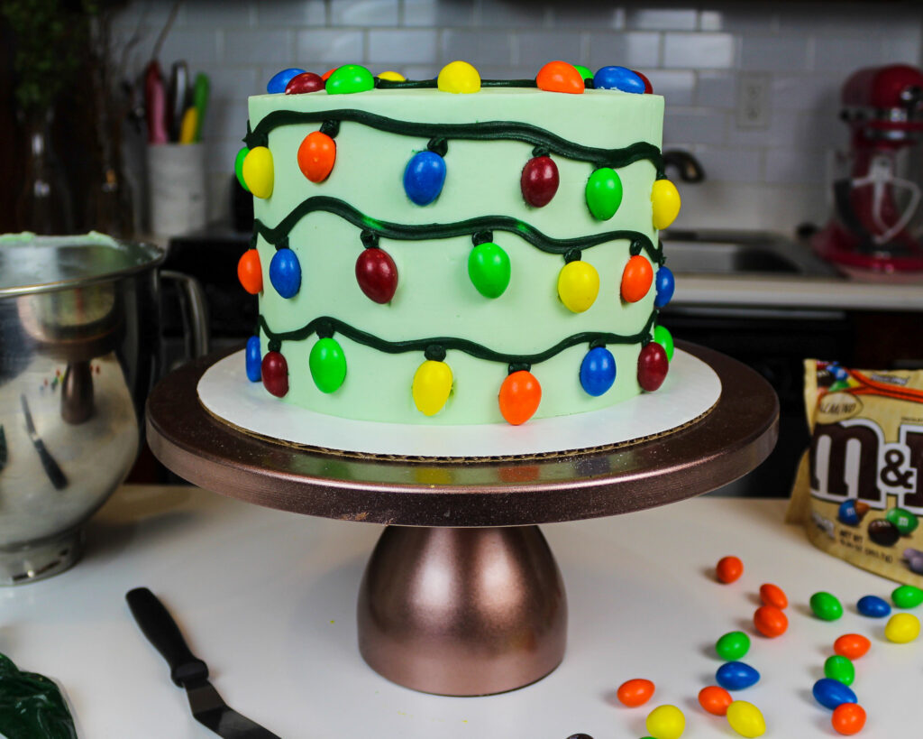 image of a christmas lights cake decorated with almond m & ms to look just like Christmas lights