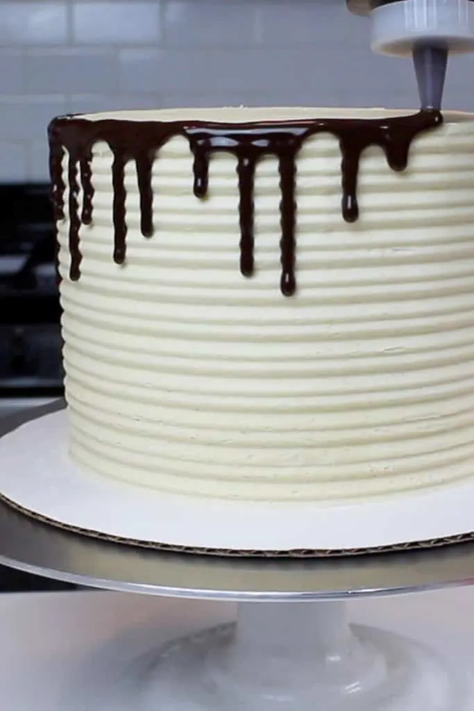 image of chocolate drips being added to a buckeye cake