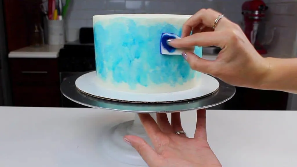 Painting the side of my buttercream cake using a mixture of gel food coloring and vodka
