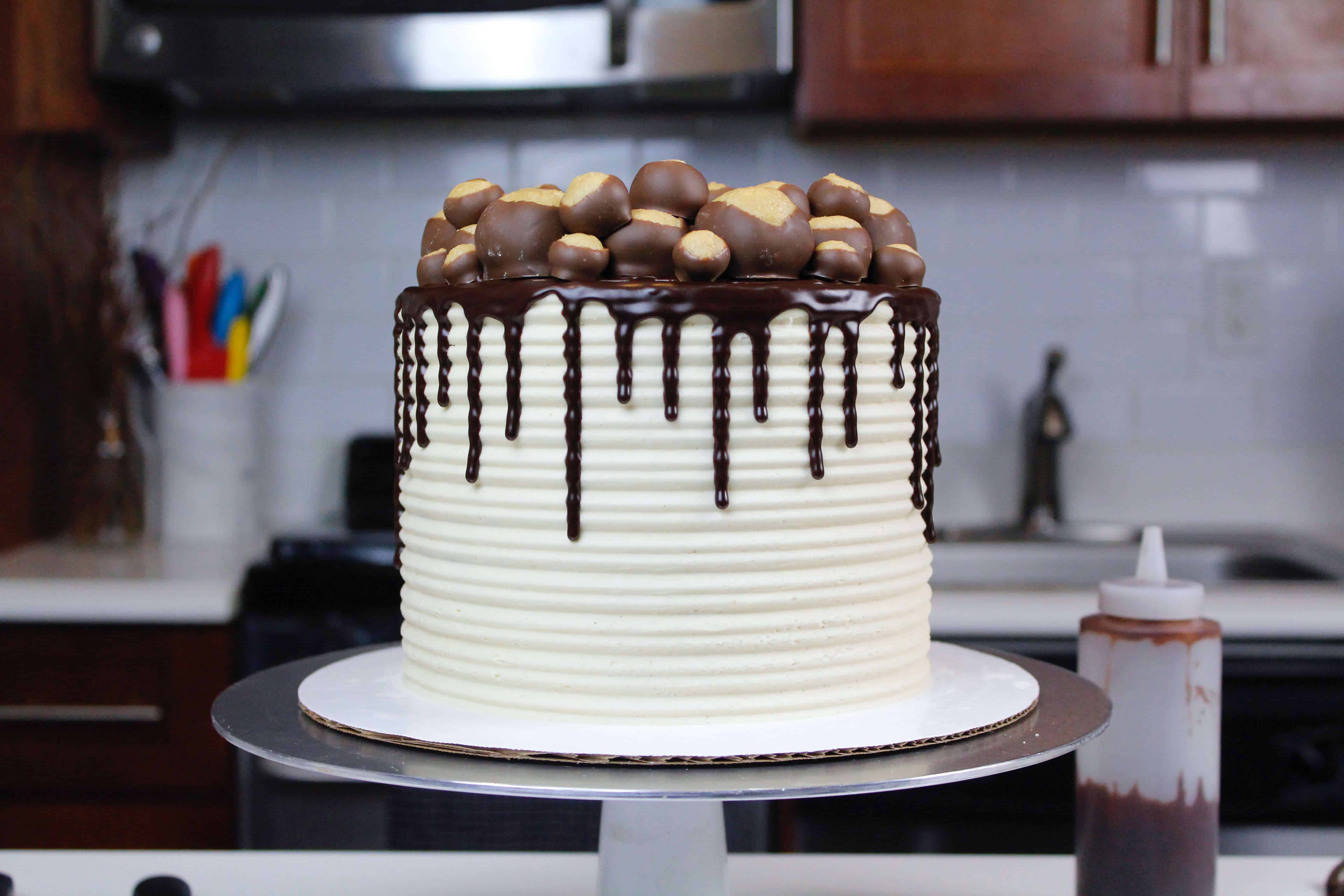 image of a buckeye cake recipe made with chocolate cake layers and decorated with buckeye balls