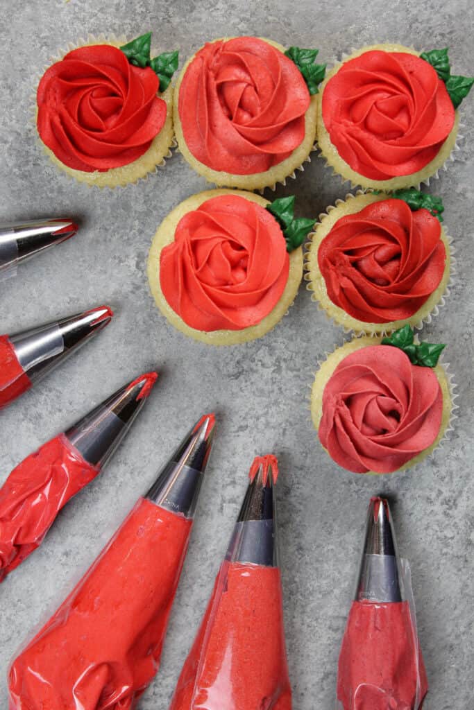 kép a piros vajkrémes rozettákkal díszített cupcake-ekről