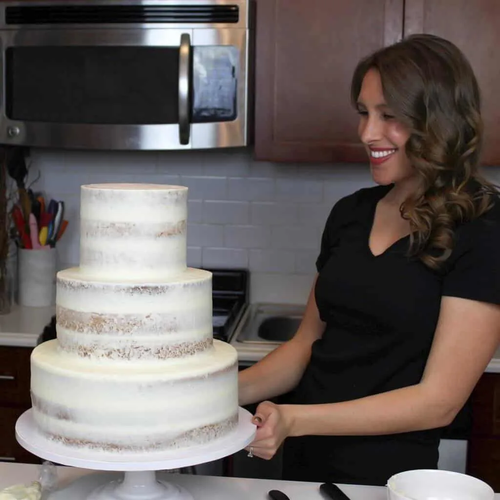 Photo of a three tiered semi naked wedding cake frosted with cream cheese frosting