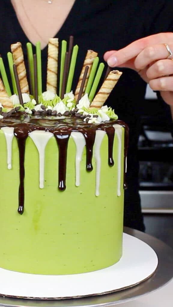 adding the finishing touches to this chocolate matcha drip layer cake