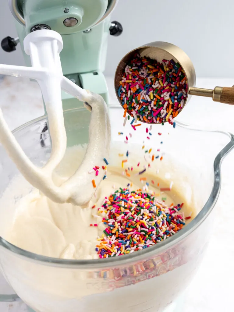 image of sprinkles being poured into cake batter