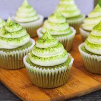 batch of matcha cupcakes, frosted with vanilla buttercream, and dusted with matcha powder