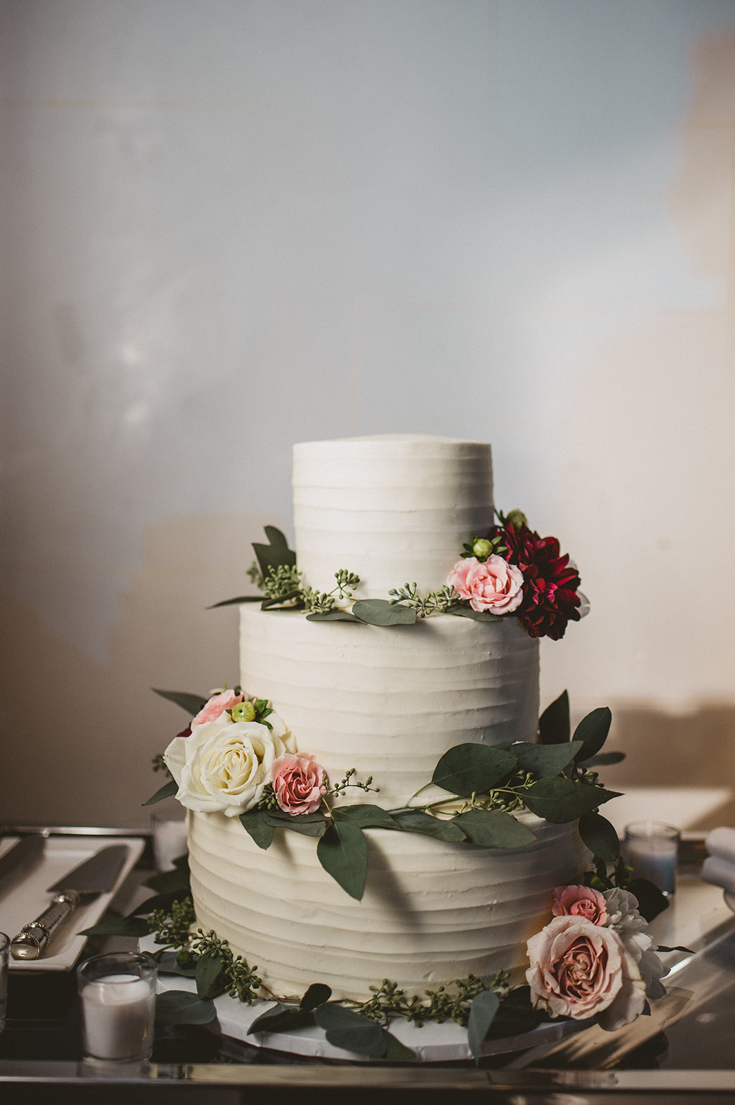 image of a wedding cake that's been decorated with buttercream and fresh flowers