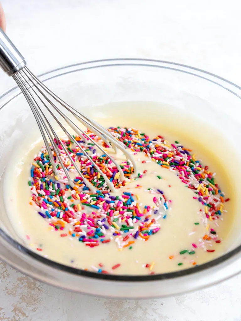 image of sprinkles being mixed into funfetti cupcake batter