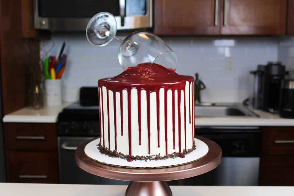 Red wine chocolate cake decorated with red wine drips, on a copper cake stand