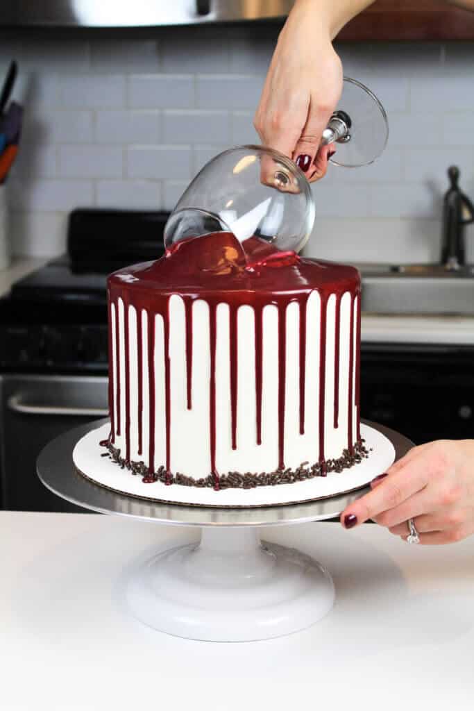 image of adding the wine glass to the top of a red wine chocolate cake 