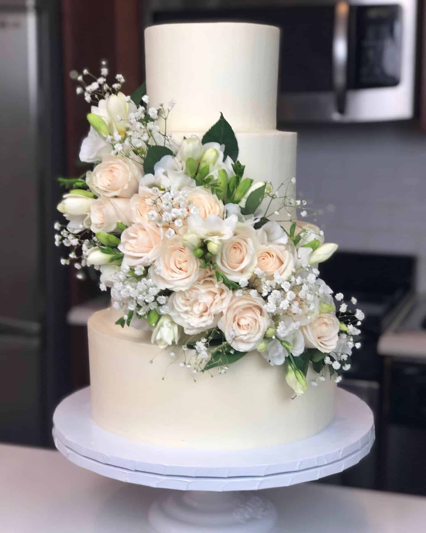 image of wedding cake with fresh white and green florals