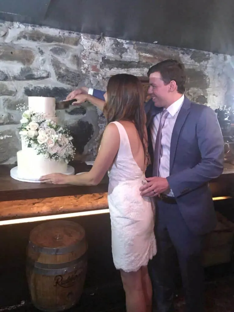 photo of chelsey white-frankola cutting into her wedding cake