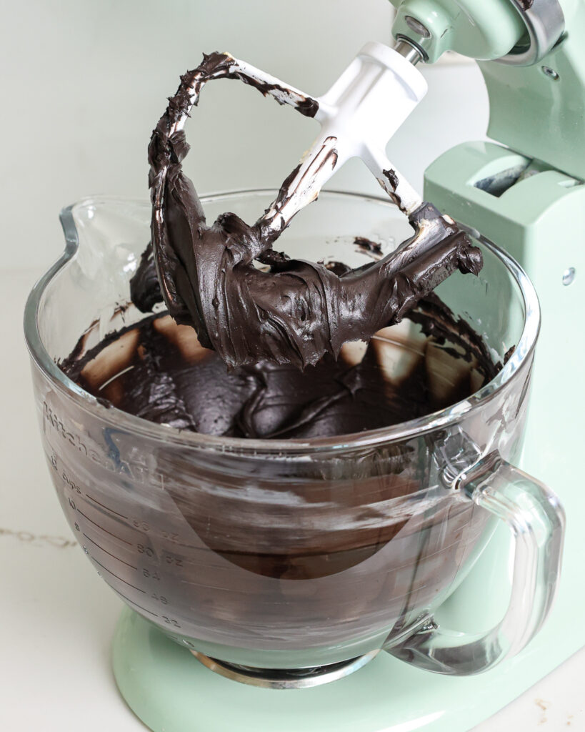 image of black buttercream frosting that's being mixed in a kitchen aid