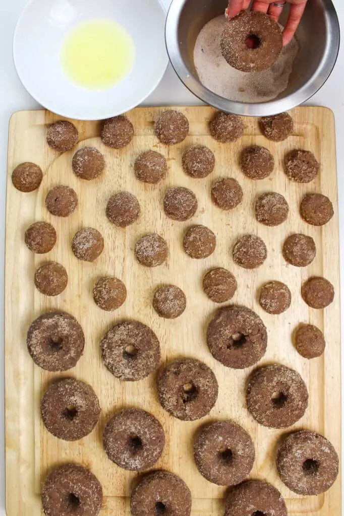 image of apple cider donuts being made from scratch and dunked in cinnamon sugar