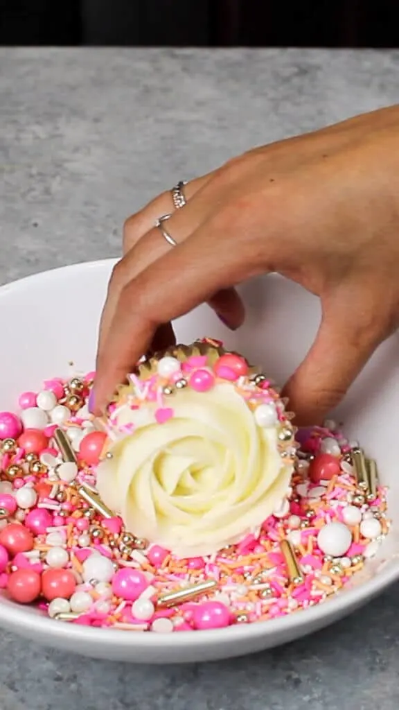 image of adding sprinkles to side of cupcake